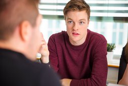Ein junger Mann im Gespräch mit einem anderen Mann | © kjekol - Getty Images/iStockphoto